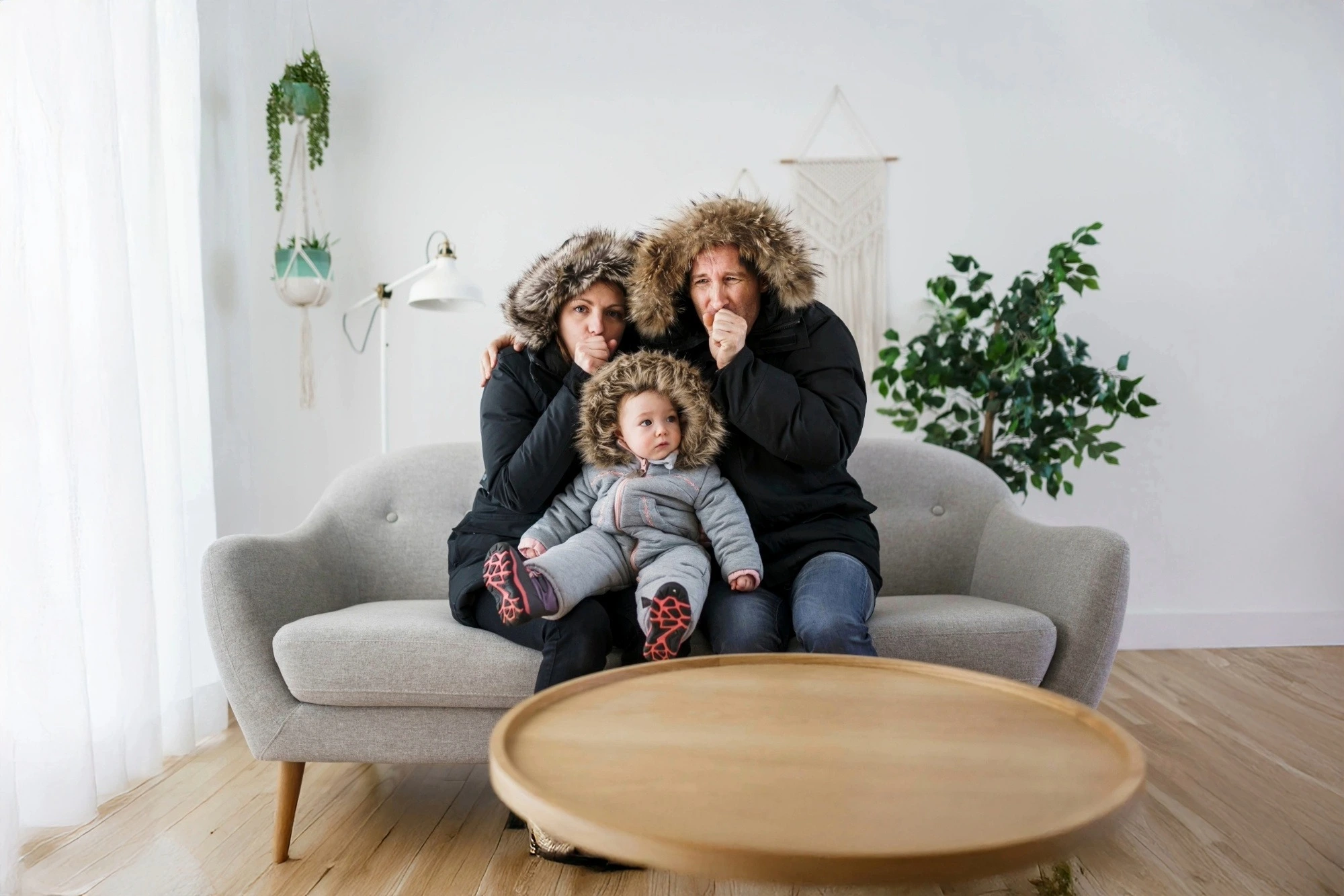 Indoor family bundled up from a broken furnace, highlighting heating repair needs – Schmidt Heating and Cooling.